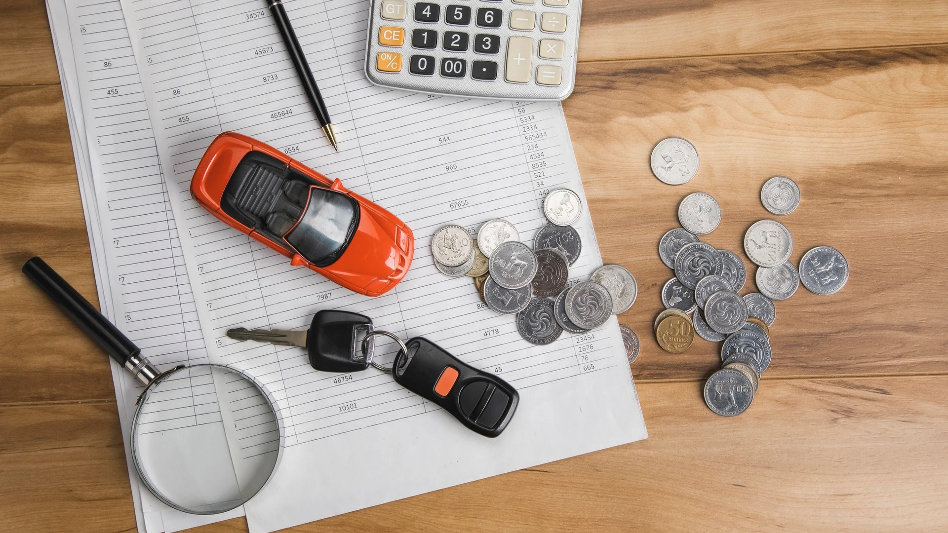 Car with key and coins on document