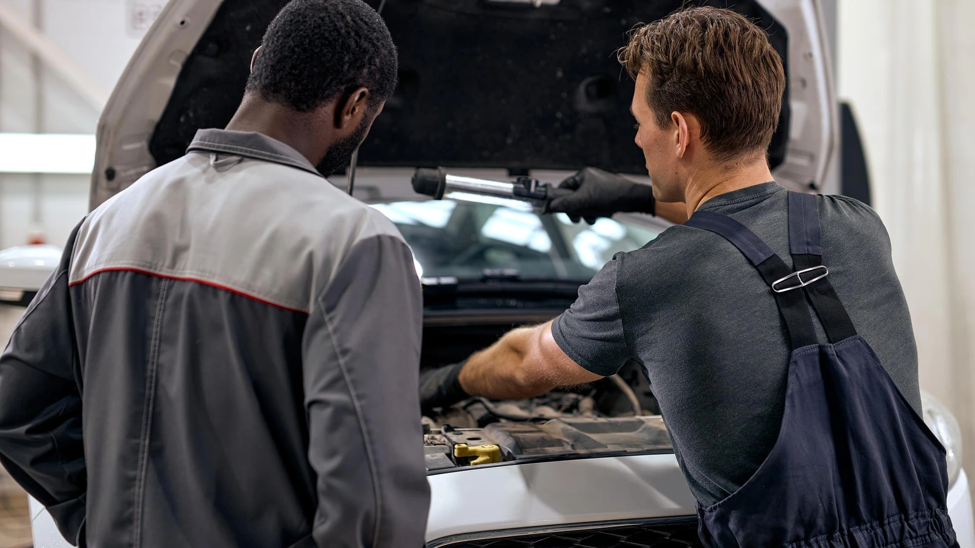 Black and american or caucasian men can fix anything handsome car mechanics in overalls uniform chec