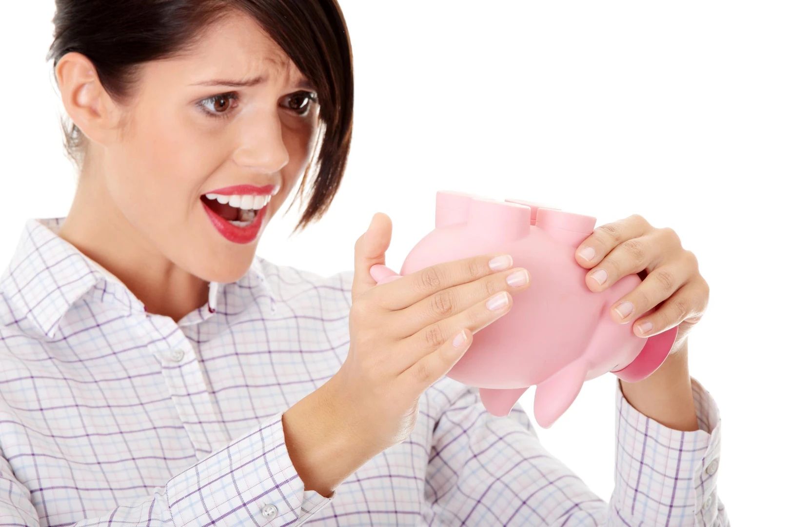 Frustrated businesswoman holding empty piggy bank against white background