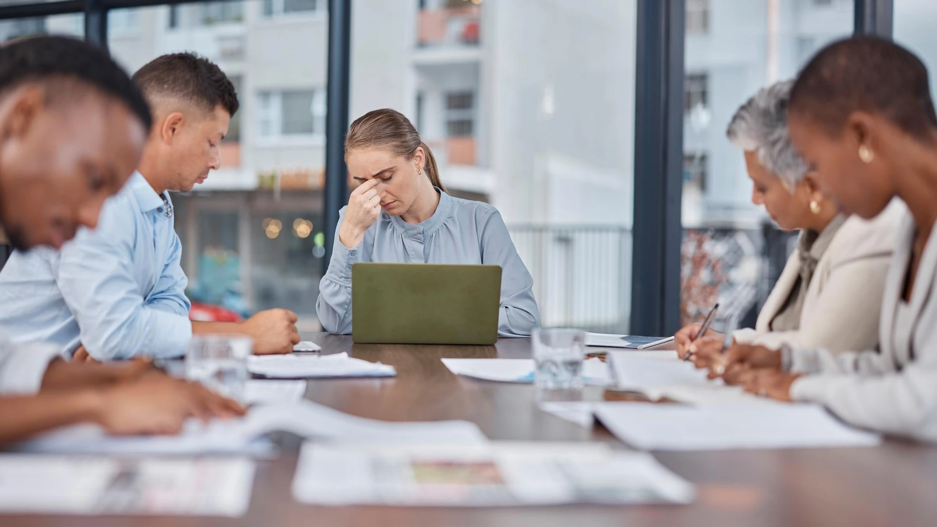 Business people team and woman with headache in meeting at office mistake and fail Stress group and person frustrated in prob
